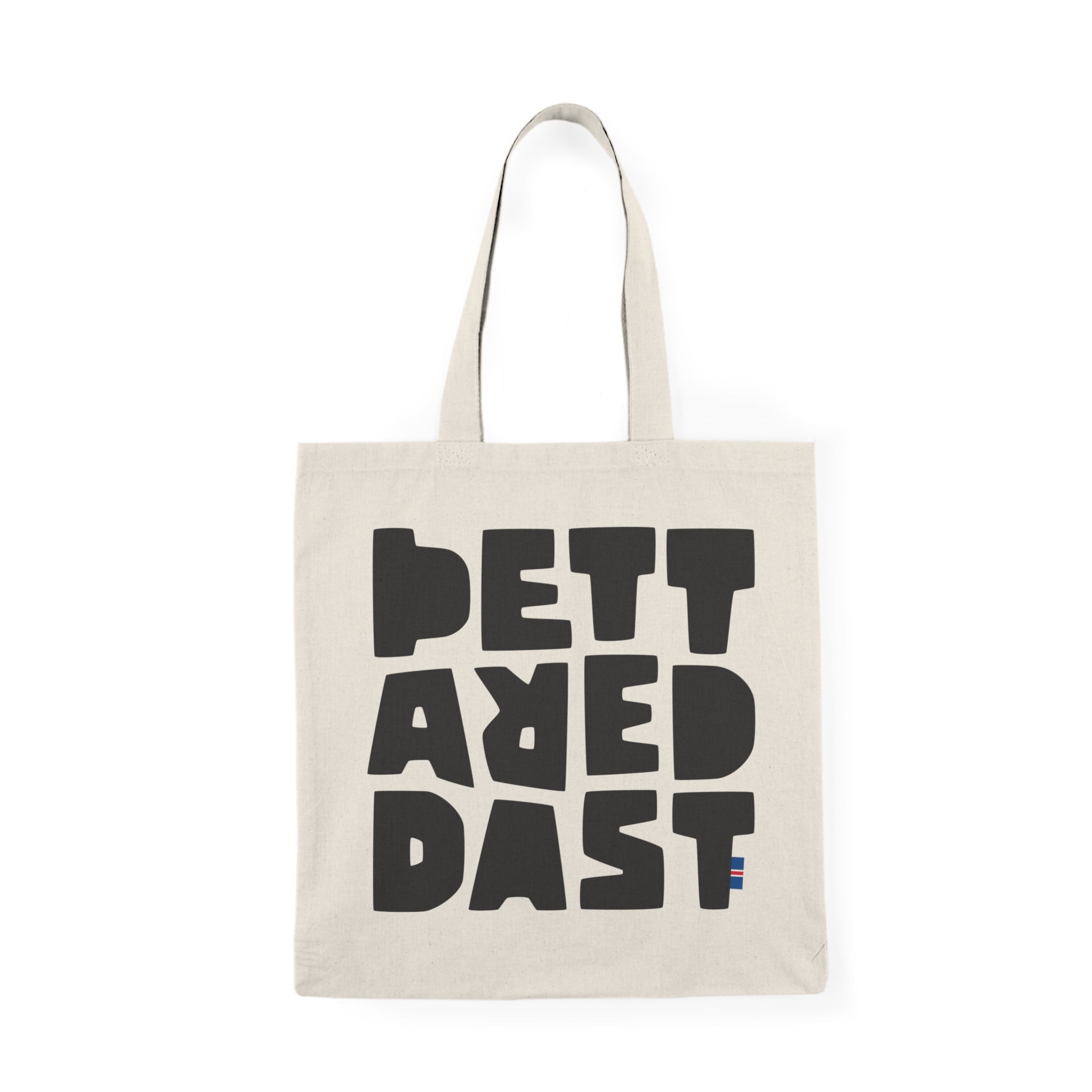 The Tote Bag Natural by Printify is a natural-colored cotton tote featuring large, bold black letters spelling "PETT ARED DAST" on the front—a stylish and eco-friendly choice for daily use.