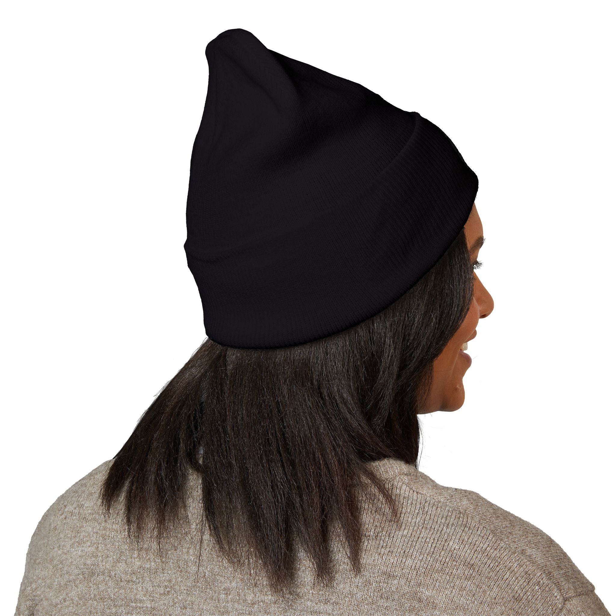 A person with long dark hair is shown from behind at a slight angle, wearing Printify’s Embroidered Cuffed Beanie—Subtle 'Pet Area Baby' Black Knit Hat—and a beige hypoallergenic acrylic sweater.
