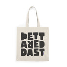 The Tote Bag Natural by Printify is a beige cotton tote featuring bold black "PETT AREDAST" text in a blocky font and a small striped accent at the bottom right—a sustainable choice ideal for daily use.