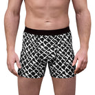 A man stands facing forward, shown from mid-thigh to waist, wearing Printify Men's Boxer Briefs (AOP) with a black and white pattern.